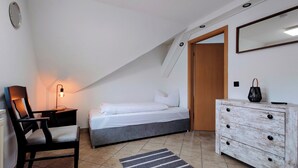 A bedroom with a bed, a desk with a lamp, a dresser, and a mirror. - Old bakery Ottendorf-Okrilla #Elfriede# (Ottendorf-Okrilla)