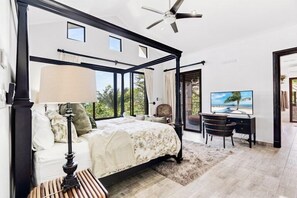 A bedroom with a four-poster bed, a desk, a chair, and a television. - New Listing • 3BR Villa • Pacifico • Private Pool • Ocean View (Playas del Coco)