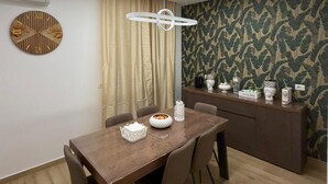 A modern dining area with a wooden table, chairs, a decorative clock, and a patterned wallpaper. - Elled-home (Misterbianco)