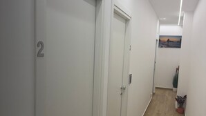 A hallway with three white doors, numbered 2, 3, and 4, leading to individual rooms. - Elled-home (Misterbianco)