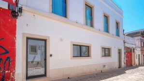A building with a white facade, multiple windows, and a cobblestone street. - Marina Legacy I Boutique Residence (Faro)