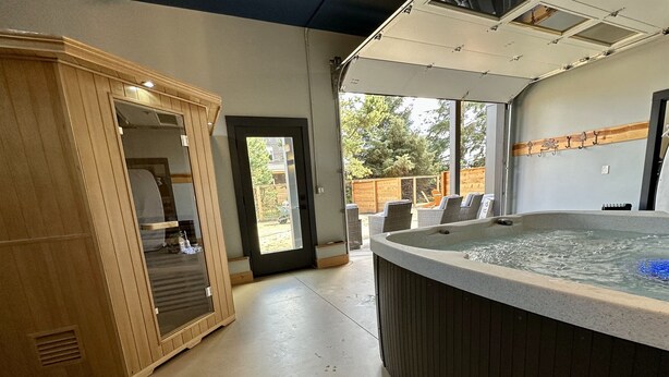 A spa area with a hot tub, wooden cabinets, and a view of the outdoors. - Villa w/ Spa, Theater, Arcade & Hot Tub · Pets OK (Ocean Shores)