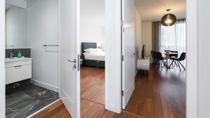 Ein Hotelzimmer mit Bad, einem Bett, einem Essbereich und Blick nach außen.