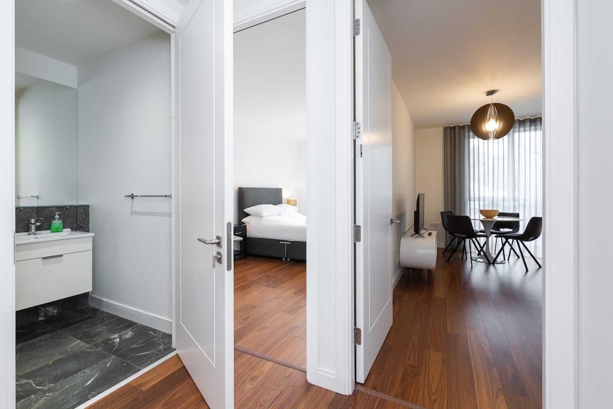 Quarto de hotel com banheiro, cama, área de refeições e vista para o exterior.