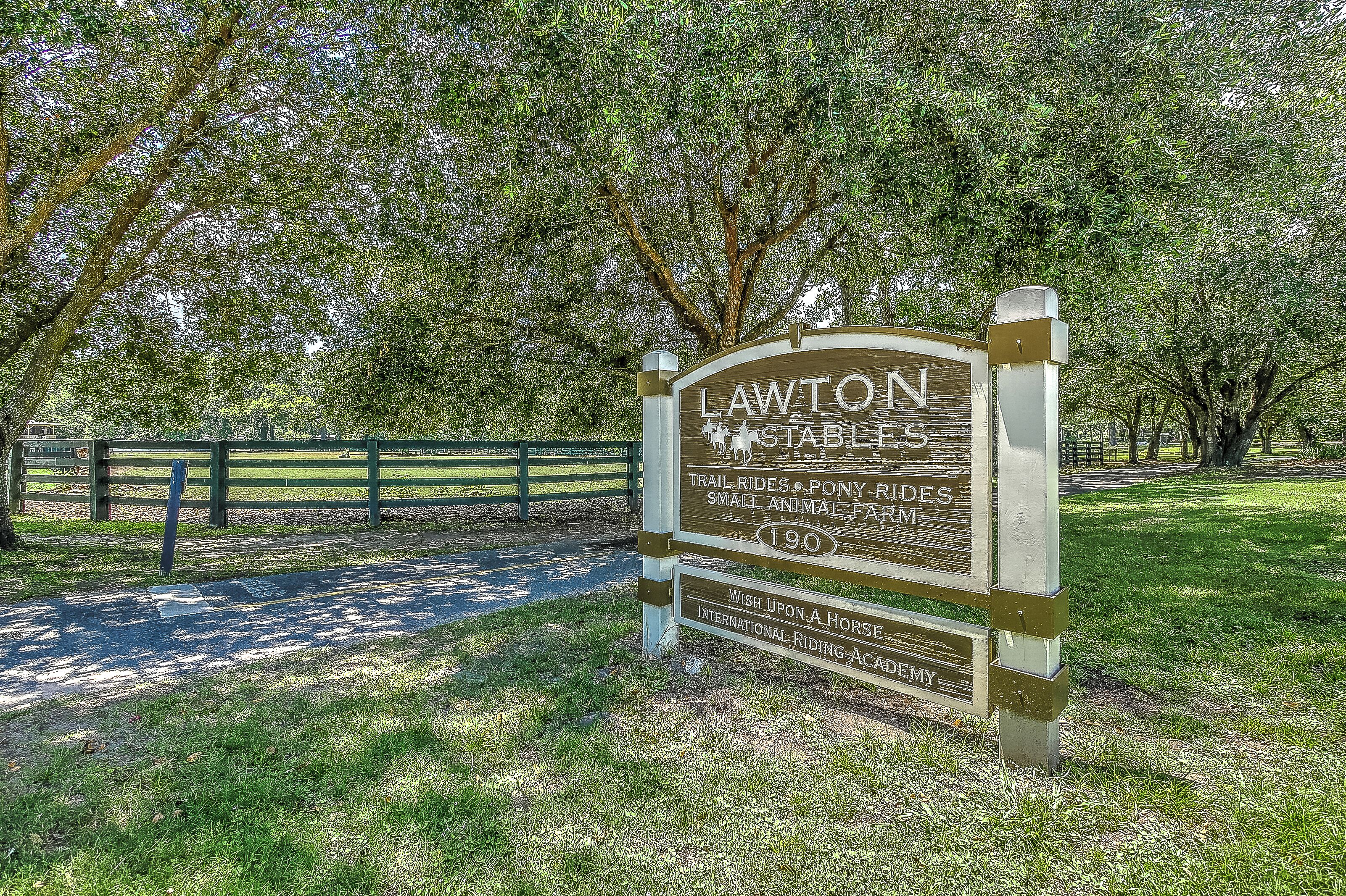 A sign for Lawton Stables with amenities like trail rides, pony rides, and a small animal farm.