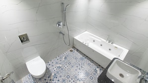 Un baño con inodoro blanco, bañera y lavabo.