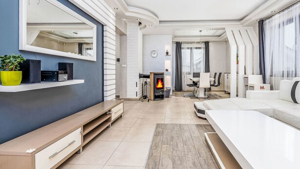 Un salon moderne avec une cheminée, un coin repas et un grand miroir.