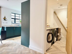 A modern kitchen with a built-in washing machine and a dining area with a table and chairs.