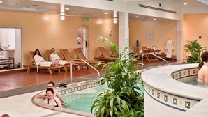 A hotel lobby with a pool area, lounge chairs, and a spa room. - Up to Par in Hot Springs Village, AR (Hot Springs Village)