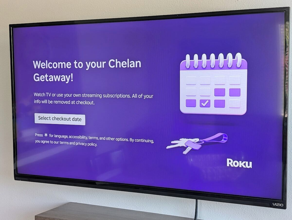 A television screen displaying a welcome message for a Chelan getaway, with options to select a checkout date and information about TV or streaming subscriptions.