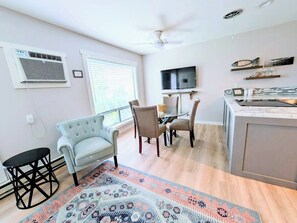 A modern living room with a sofa, chairs, a coffee table, and a TV. - Lake Breeze Retreat · Newly Remodeled · Lake Views (Chelan - Beach Bungalows)