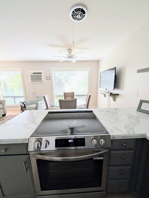 A modern kitchen with a built-in stove, oven, and a ceiling fan. - Lake Breeze Retreat · Newly Remodeled · Lake Views (Chelan - Beach Bungalows)