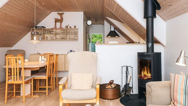 Un salon chaleureux avec une cheminée, des meubles en bois et un coin repas.