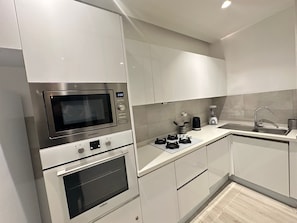 A modern kitchen with a built-in microwave, oven, and a coffee maker on the countertop. - Charming apartment in the heart of La Marsa - Near beach, Carthage & Tunis (La Marsa)