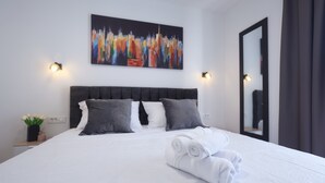 A hotel room with a neatly made bed, a cityscape painting, and a mirror on the wall. - 3-bedroom villa in gorgeous Zaton with cool AC (Zaton)