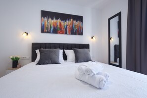A hotel room with a neatly made bed, a cityscape painting, and a mirror on the wall. - 3-bedroom villa in gorgeous Zaton with cool AC (Zaton)