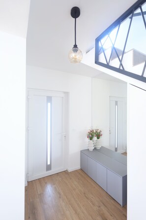 A room with a wooden floor, a white door, a grey cabinet, a large mirror, and a hanging light fixture. - 3-bedroom villa in gorgeous Zaton with cool AC (Zaton)