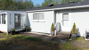 A white mobile home with a 'WELCOME' sign, two potted plants, and a small step leading to the door. - Fire Pit, Grill, 3bd, 2ba, Dogs Ok, Fully Fenced Yard (Allee) (Aberdeen)