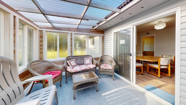 A sunroom with wicker furniture, a glass door leading to a dining area, and a ceiling with skylights. - Fire Pit, Grill, 3bd, 2ba, Dogs Ok, Fully Fenced Yard (Allee) (Aberdeen)