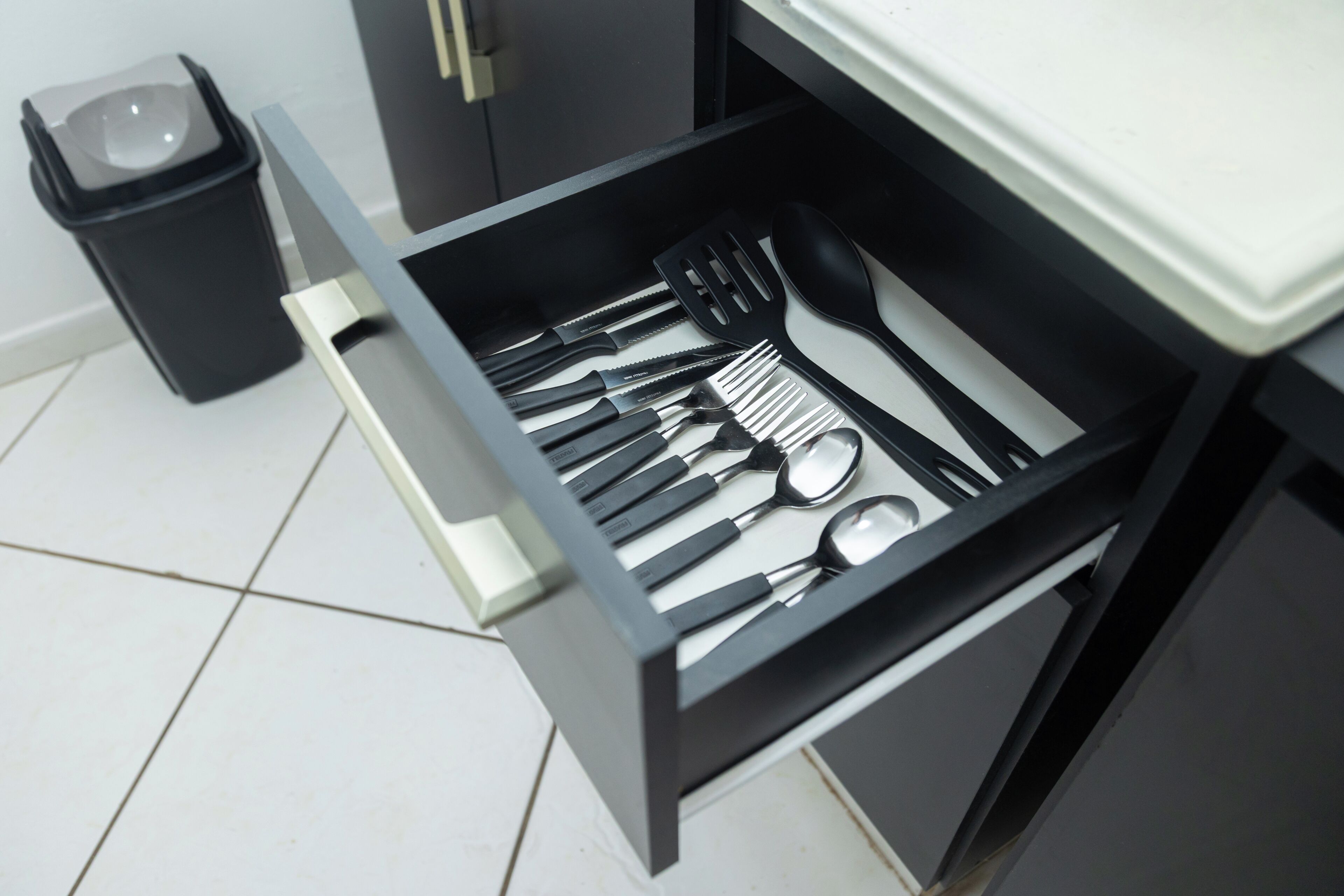 Un cajón de cocina con utensilios.
