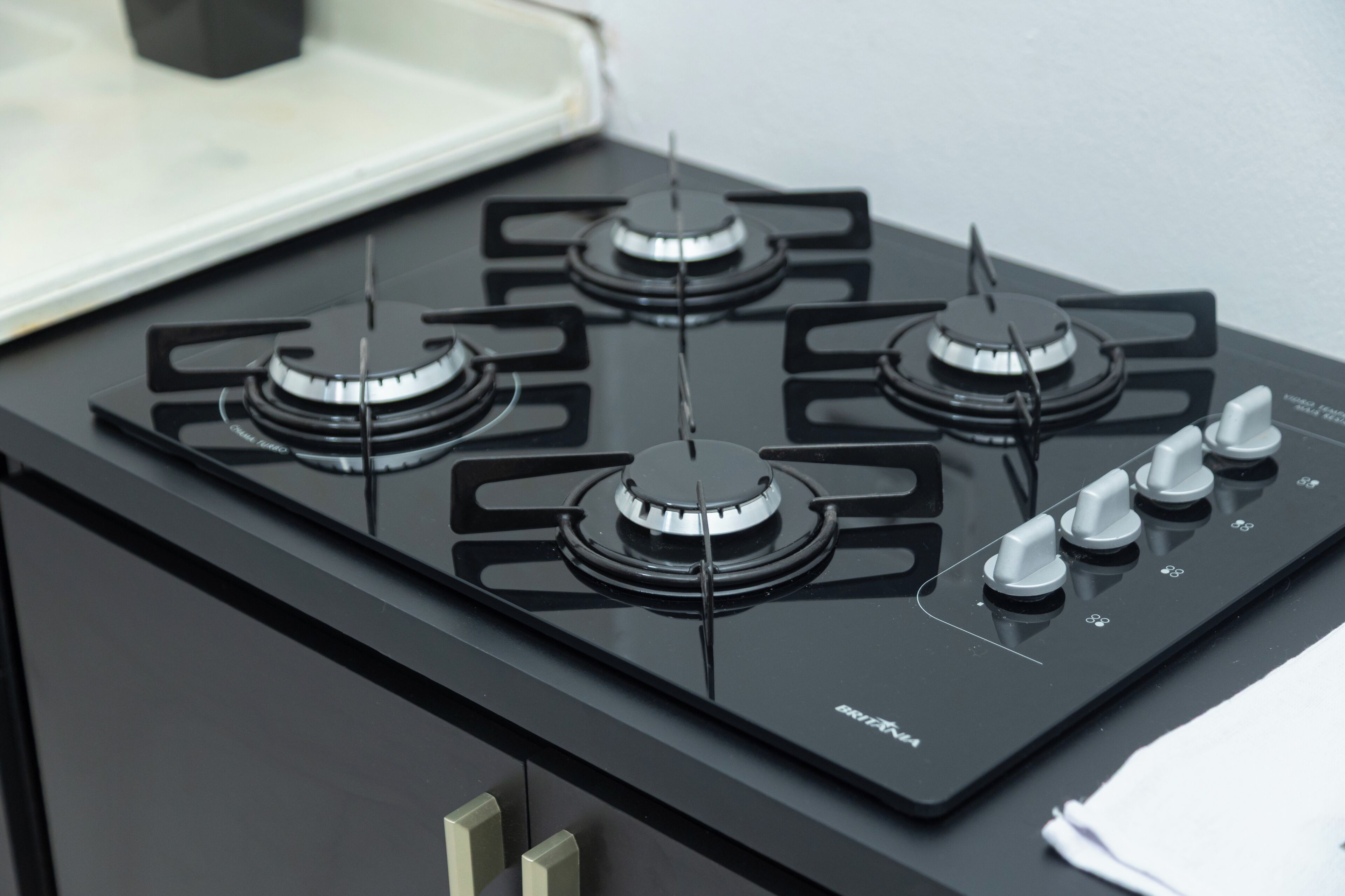 A black stove with four burners and a control panel with knobs.