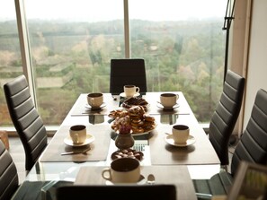 A dining table with chairs, a laptop, and a view of a landscape through large windows. - Wohnung mit Panoramaverglasung und Meerblick by Interhome (Dziwnówek)