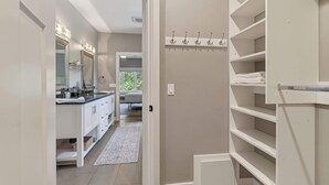 A hallway leading to a bathroom with a vanity, a mirror, and a towel rack. - Fish Creek home- near downtown w/ Fire pit (Fish Creek)