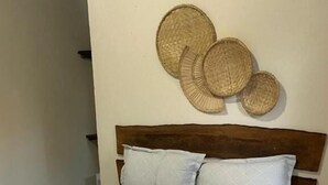 Una cama con colcha estampada, dos almohadas y cabecera.