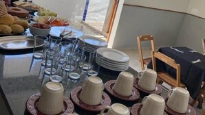 Un comedor con mesas de buffet, con platos, tazones y vasos.