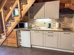 A kitchen with wooden cabinetry, a built-in microwave, a kettle, and a dishwasher. - Willa Kinga z kominkiem by Interhome (Rewal)