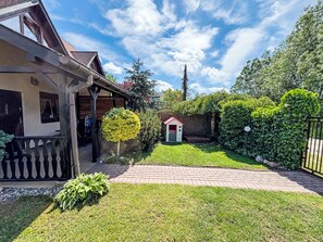 A residential property with a paved driveway, a small garden, and a wooden fence. - Willa Kinga z kominkiem by Interhome (Rewal)