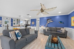 Ein Wohnzimmer mit zwei Sofas, einem Couchtisch und einem Deckenventilator.