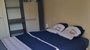 Une chambre à coucher avec un lit, une armoire et une table de chevet.