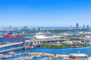 A cityscape with a cruise ship docked, a marina with boats, and a bridge. - Luxury 2-Bedroom Apartment in Downtown Miami with AC (Miami)