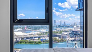 Blick auf eine Stadtlandschaft aus einem Fenster, darunter ein Riesenrad und moderne Gebäude.