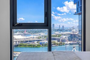 A cityscape view from a window, including a Ferris wheel and modern buildings. - Luxury 2-Bedroom Apartment in Downtown Miami with AC (Miami)