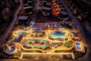 Oversigtsbillede af et resort med flere swimmingpools, en stor central plads og flere bygninger.