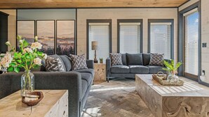 Un salon moderne avec un canapé, une table basse et un vase rempli de fleurs.