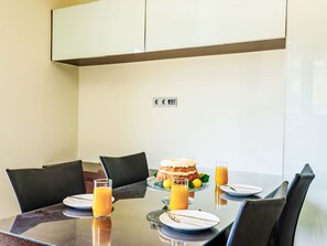 A dining table with chairs, a cake, and glasses of orange juice. - Villa Lamon by Interhome (Agios Vasilios)
