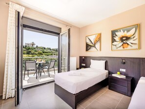 A hotel room with a bed, a nightstand, a chair, a table, and a balcony with a view. - Villa Lamon by Interhome (Agios Vasilios)