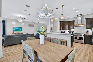A modern kitchen with a central island, built-in cabinets, and a stainless steel range hood. - Sugar Palm | Steps to Beach, Heated Pool, FREE Golf Cart, Game Room, Bunk Rooms (Miramar Beach)