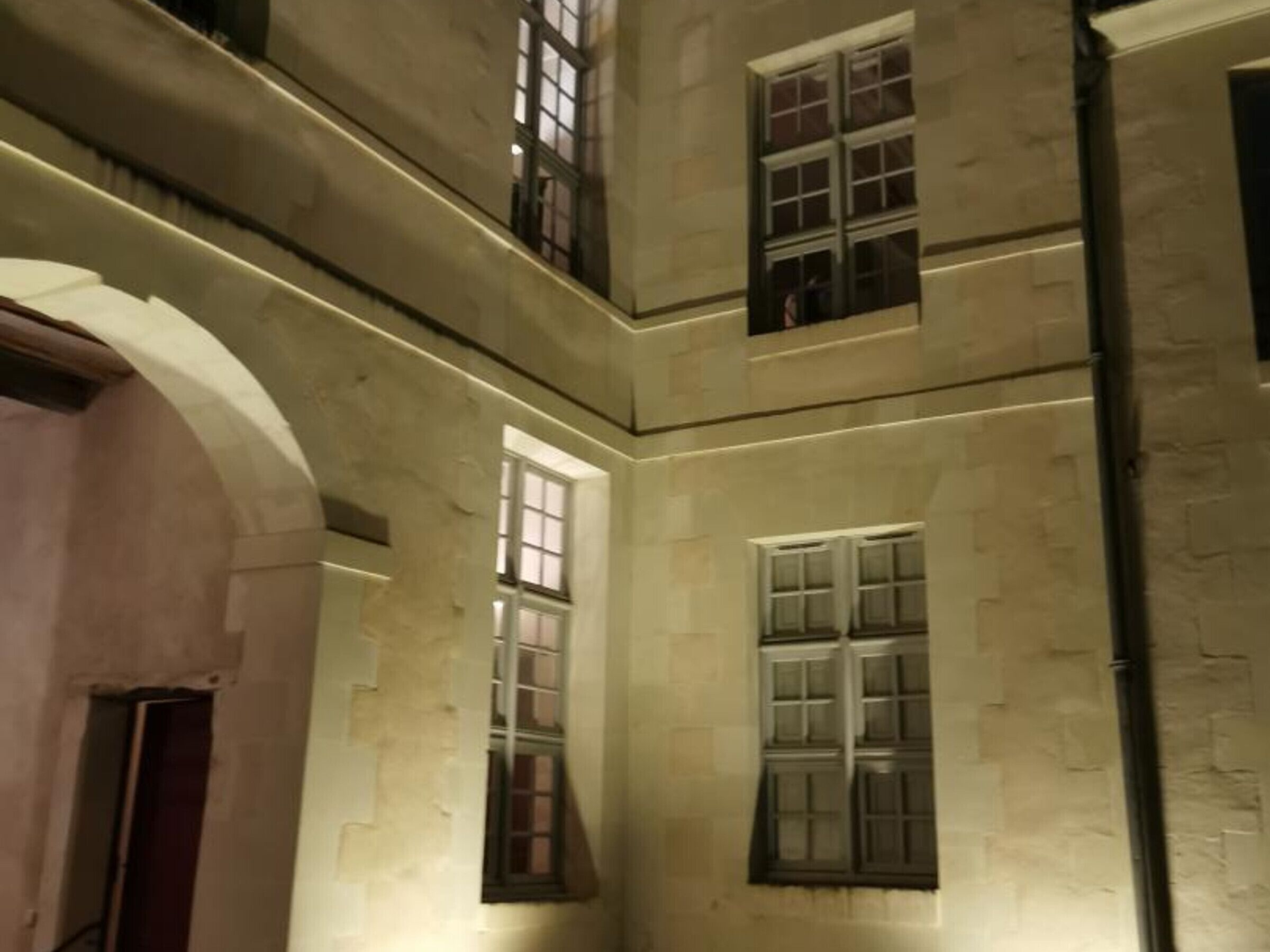 A multi-level building with arched doorways and multiple windows.