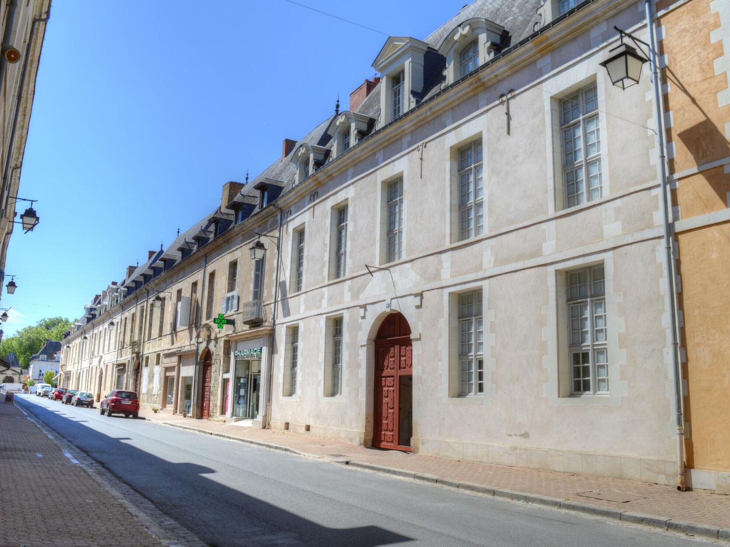 A historic building with a pharmacy on the ground floor, large windows, and a classic architectural style.