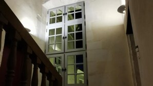 Een trap met een houten leuning die leidt naar een kamer met een groot raam.