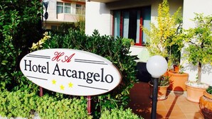 Une enseigne d’hôtel portant le nom « Hôtel Arcangelo » et affichant trois étoiles.