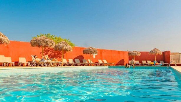A swimming pool with lounge chairs and thatched umbrellas. - Comfortable mobile home with terrace - 4 guests (Vic-la-Gardiole)