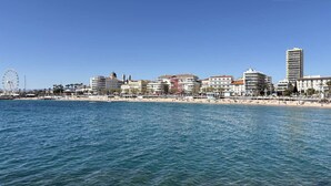 A coastal cityscape with a beach, a Ferris wheel, and various buildings. - Studio cabin sea view - 4 guests (Saint-Raphaël)