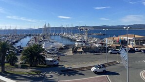 A marina with boats docked, a parking area, and a building with a sign. - Studio cabin sea view - 4 guests (Saint-Raphaël)