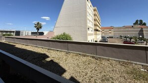 A building with a flat roof, a parking lot with several cars, and a clear blue sky. - Studio near fish market - 4 guests (Arcachon)
