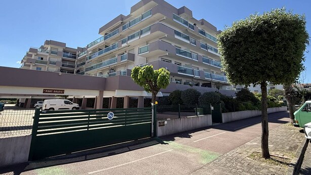 A multi-story building with a sign reading 'PORT SOLEIL' at the entrance, a gated parking area, and a clear blue sky. - Studio near fish market - 4 guests (Arcachon)